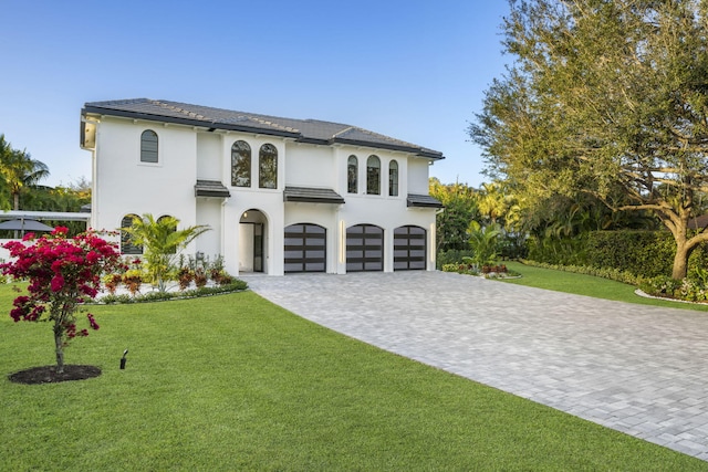 mediterranean / spanish home featuring a front yard and a garage