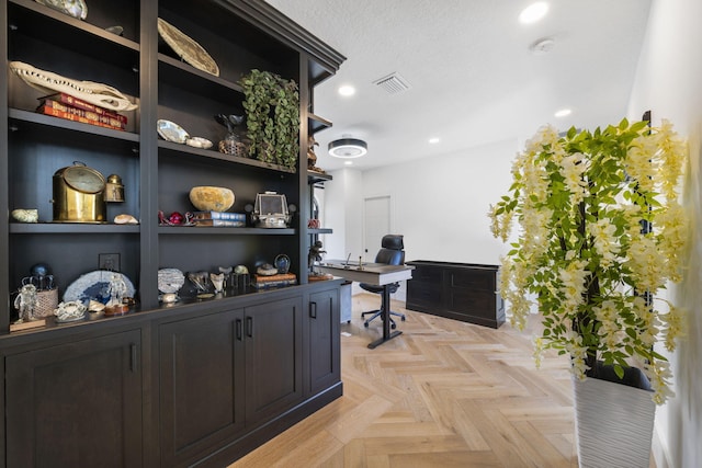 office space with light parquet flooring and a textured ceiling