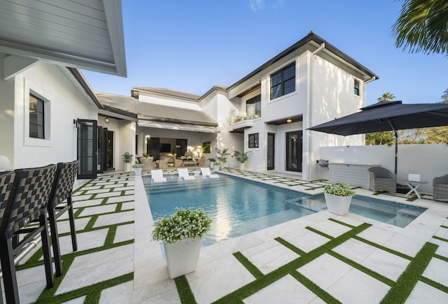 view of swimming pool featuring a patio and a jacuzzi