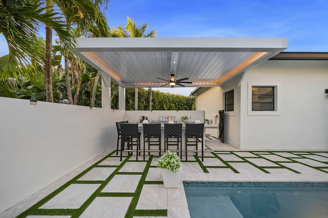 view of patio featuring a bar, a fenced in pool, and ceiling fan