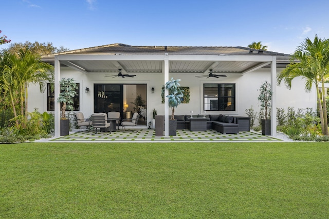 back of property featuring ceiling fan, outdoor lounge area, and a lawn