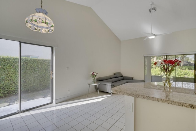 interior space with ceiling fan, plenty of natural light, light tile patterned flooring, and pendant lighting