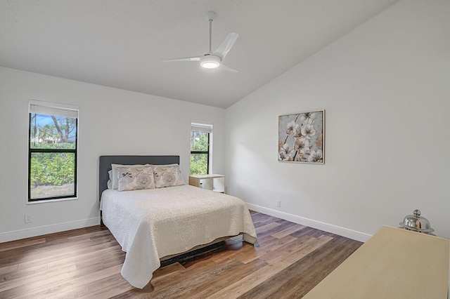 bedroom with ceiling fan, high vaulted ceiling, and hardwood / wood-style flooring