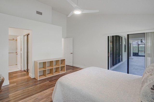 bedroom with hardwood / wood-style floors, access to outside, high vaulted ceiling, and ceiling fan