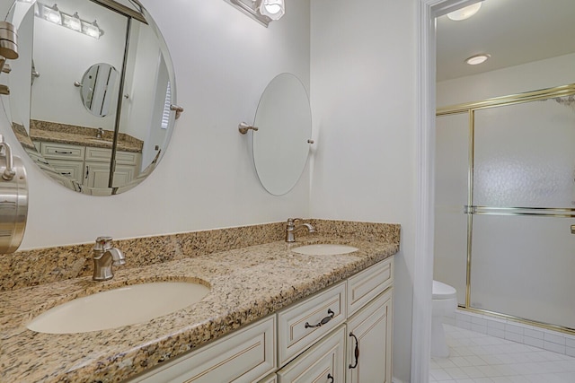 bathroom with tile patterned floors, vanity, toilet, and a shower with shower door