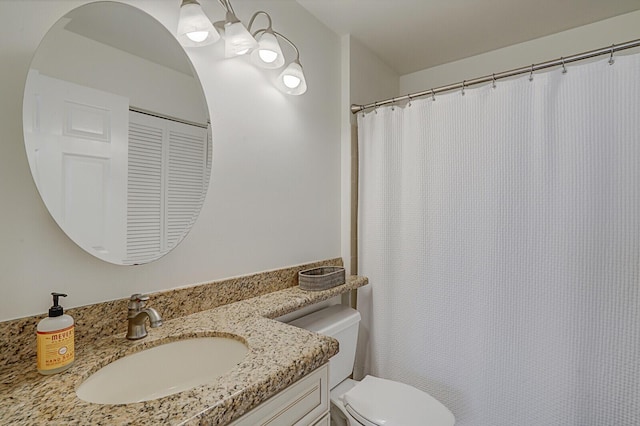 bathroom with a shower with shower curtain, vanity, and toilet