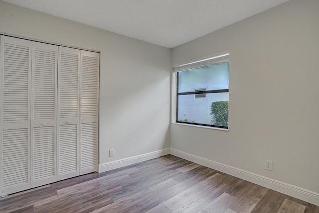 unfurnished bedroom with a closet and light hardwood / wood-style flooring