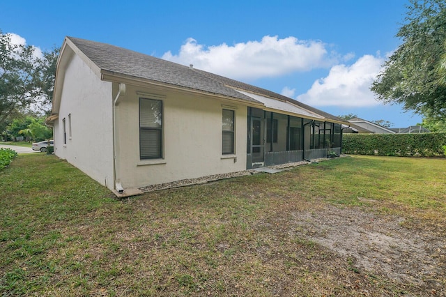 rear view of property featuring a lawn and a sunroom