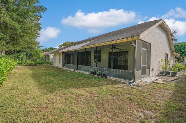 rear view of house with a yard, ceiling fan, and a sunroom