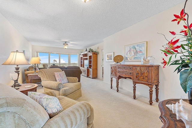 living room featuring a textured ceiling, light colored carpet, and ceiling fan