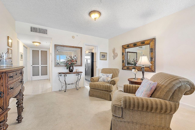 living area with light colored carpet and a textured ceiling