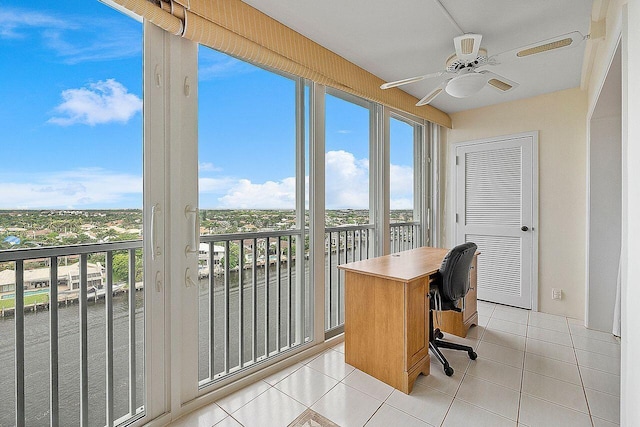 tiled office featuring ceiling fan and a water view