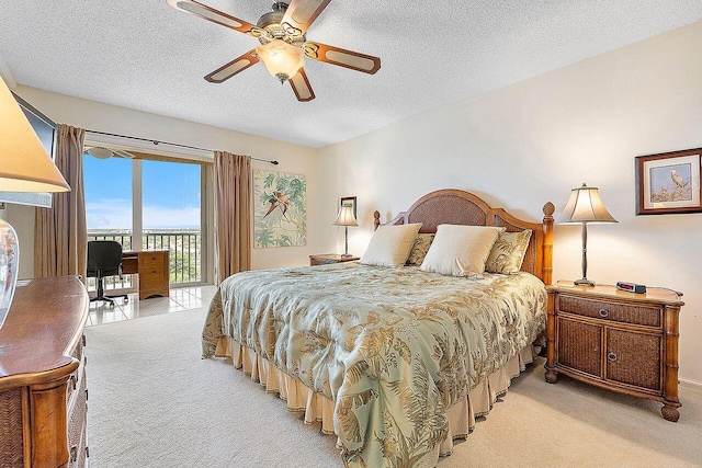 carpeted bedroom with ceiling fan, access to outside, and a textured ceiling