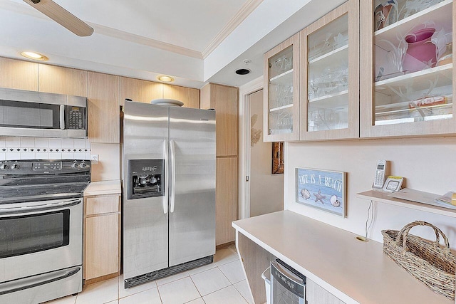 kitchen featuring crown molding, stainless steel appliances, tasteful backsplash, and light brown cabinets