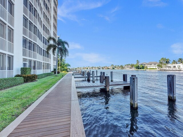 dock area with a water view and a lawn