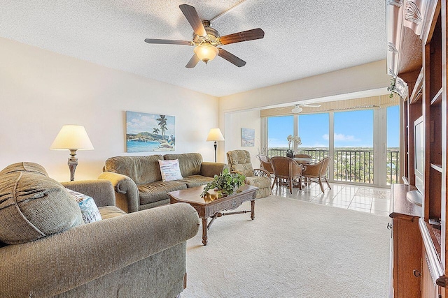 carpeted living room with ceiling fan and a textured ceiling