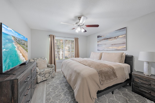 bedroom featuring ceiling fan, dark hardwood / wood-style floors, and a textured ceiling