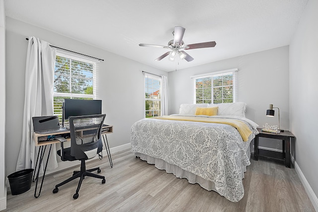 bedroom with ceiling fan and light hardwood / wood-style flooring