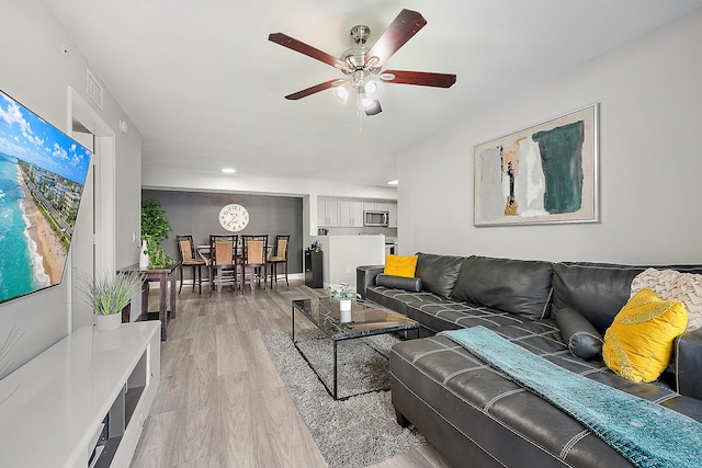 living room featuring ceiling fan and light hardwood / wood-style floors