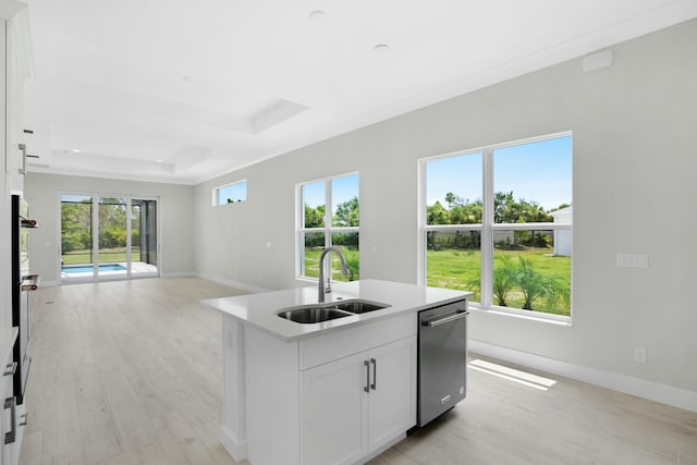 kitchen with dishwasher, a center island with sink, a raised ceiling, sink, and white cabinetry