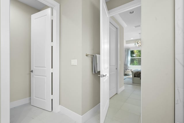 corridor featuring marble finish floor and baseboards