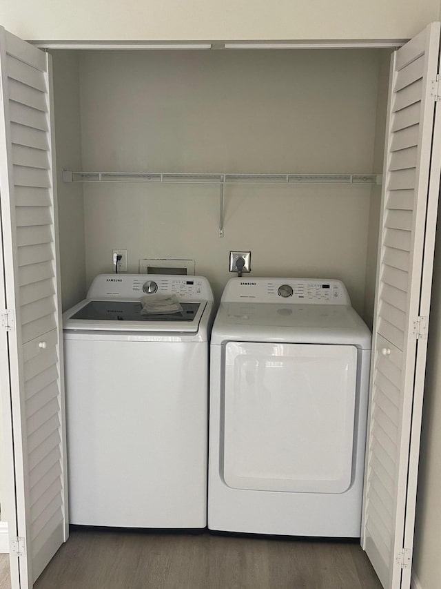 laundry area with separate washer and dryer and dark hardwood / wood-style floors