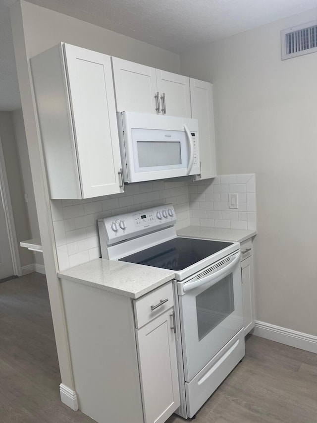 kitchen featuring white cabinets, white appliances, and tasteful backsplash