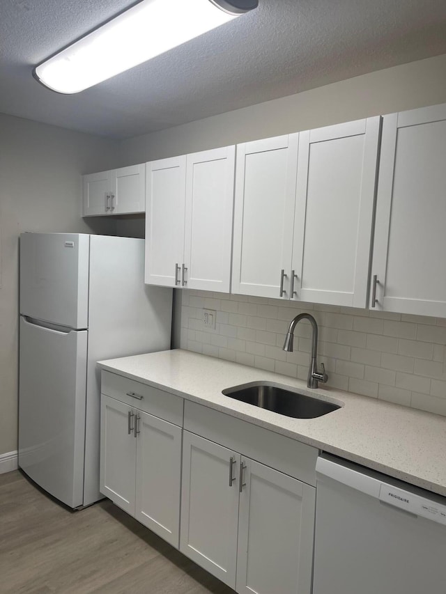 kitchen featuring white cabinetry, dishwasher, refrigerator, and sink