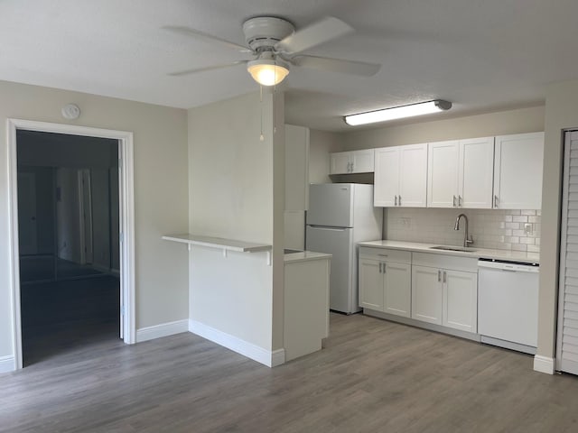 kitchen featuring sink, white cabinets, and white appliances