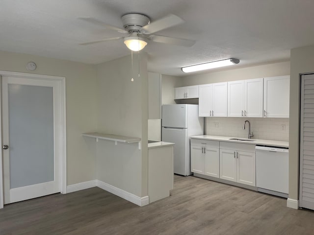 kitchen featuring ceiling fan, sink, backsplash, white appliances, and white cabinets