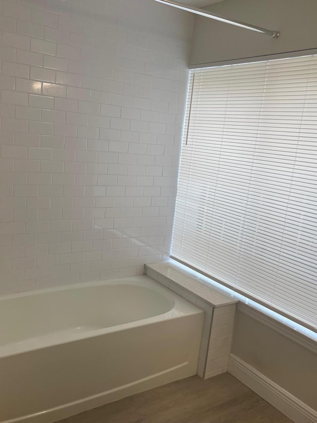 bathroom with hardwood / wood-style floors and a washtub