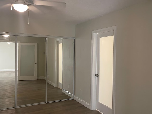 unfurnished bedroom featuring ceiling fan, dark hardwood / wood-style flooring, and a closet