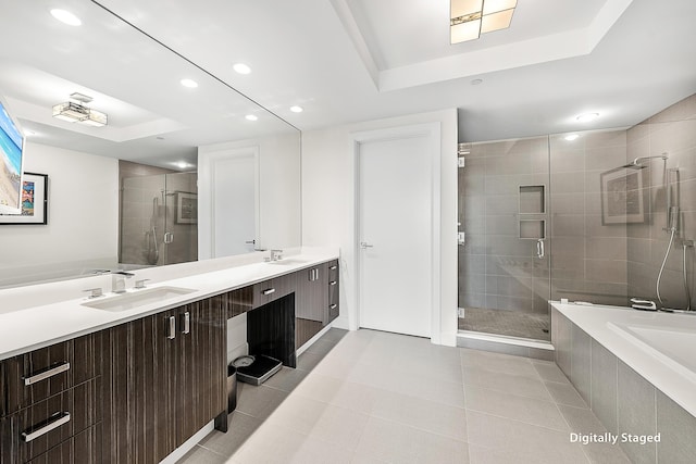 bathroom with tile patterned flooring, vanity, shower with separate bathtub, and a tray ceiling