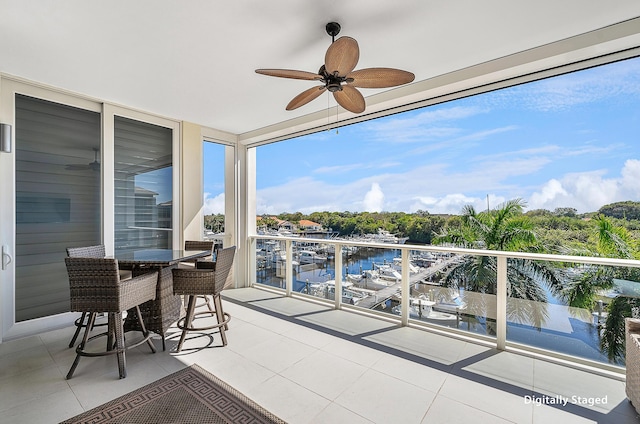 balcony with ceiling fan and a water view