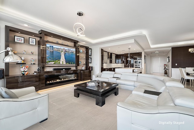 living room with a tray ceiling and sink