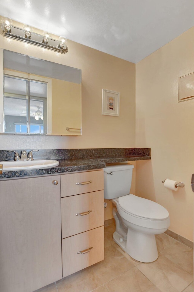 bathroom with tile patterned flooring, vanity, and toilet