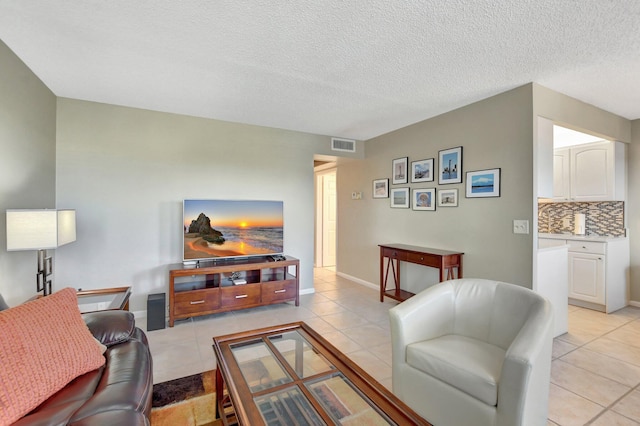 living room featuring light tile patterned flooring and a textured ceiling