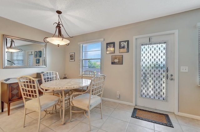 dining room featuring light tile patterned flooring and a textured ceiling