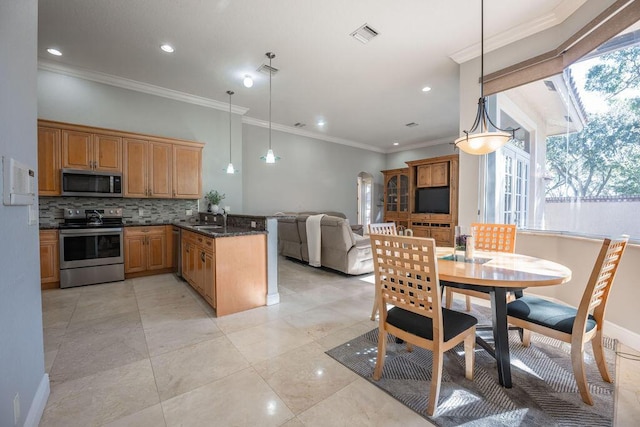 kitchen featuring appliances with stainless steel finishes, plenty of natural light, pendant lighting, and sink