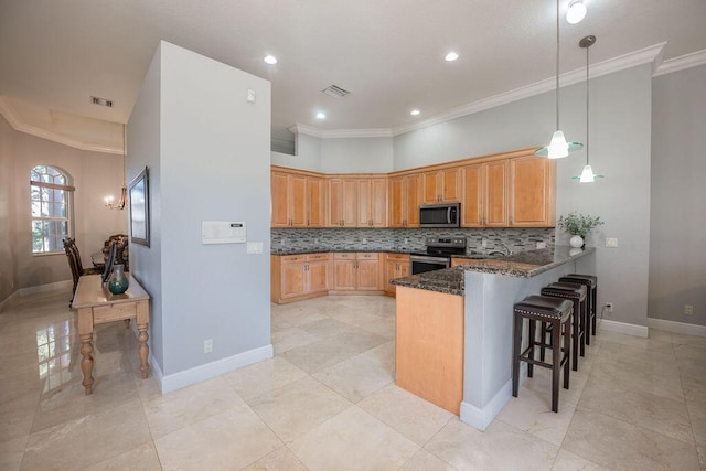 kitchen featuring kitchen peninsula, ornamental molding, stainless steel appliances, dark stone countertops, and a breakfast bar area