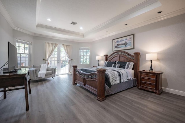 bedroom featuring a tray ceiling, crown molding, french doors, and hardwood / wood-style floors