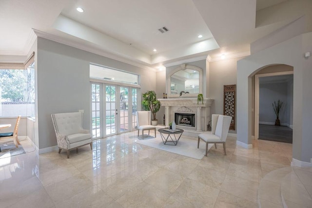 living room featuring a raised ceiling and a fireplace