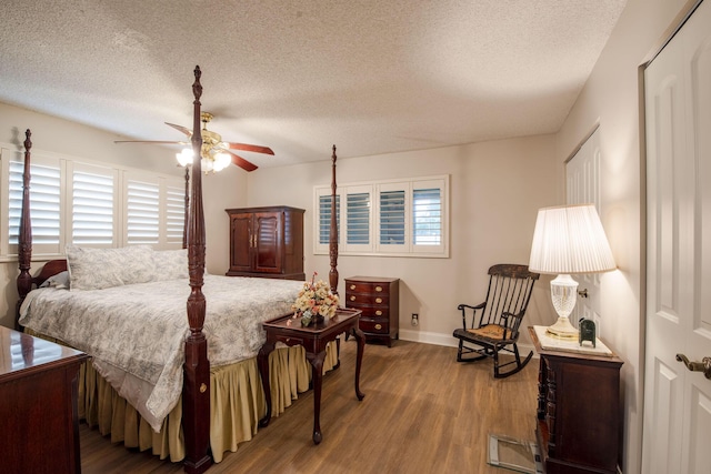 bedroom with wood-type flooring, a textured ceiling, and ceiling fan