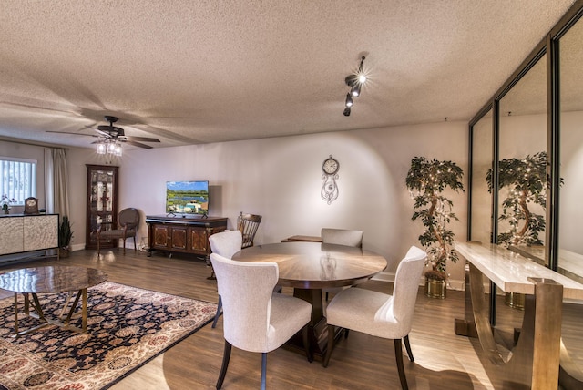 dining room with a textured ceiling, hardwood / wood-style flooring, and ceiling fan