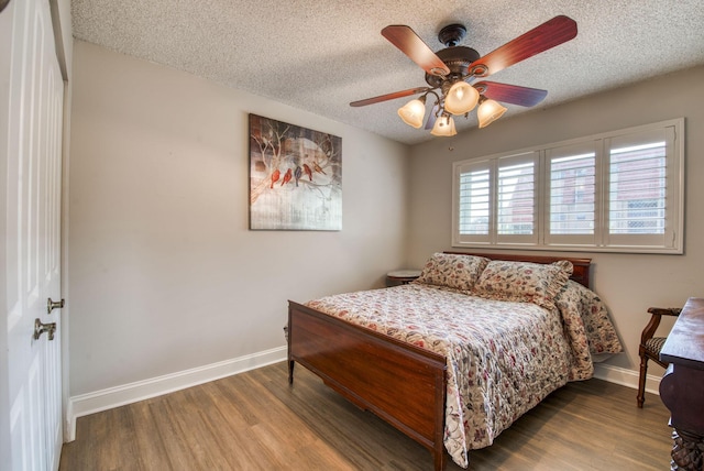 bedroom featuring ceiling fan, a textured ceiling, and hardwood / wood-style flooring