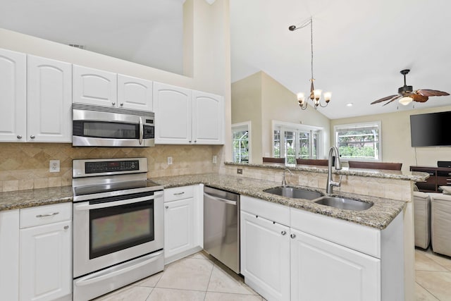 kitchen featuring kitchen peninsula, sink, vaulted ceiling, and appliances with stainless steel finishes