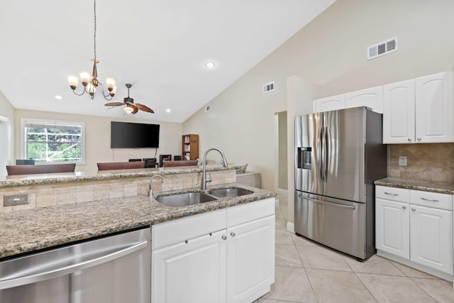 kitchen featuring sink, light stone counters, white cabinets, ceiling fan with notable chandelier, and appliances with stainless steel finishes