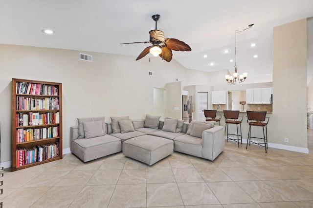 tiled living room with ceiling fan with notable chandelier and vaulted ceiling