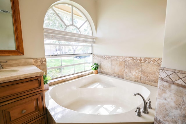 bathroom featuring vanity, a bathtub, and plenty of natural light