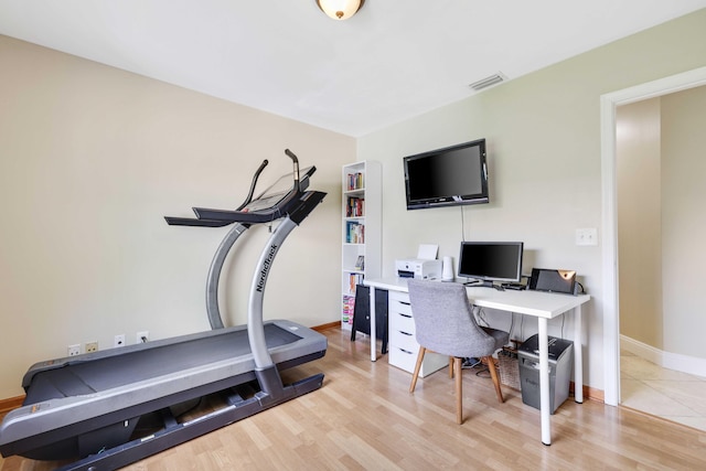 exercise room with light hardwood / wood-style floors